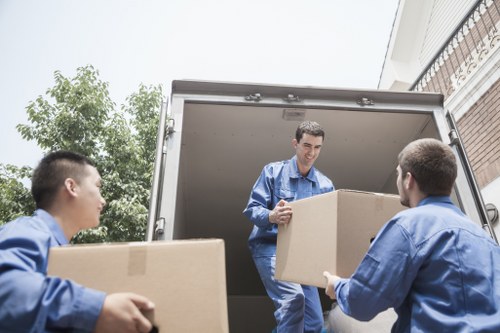 Movers handling furniture access in a New Malden residential street