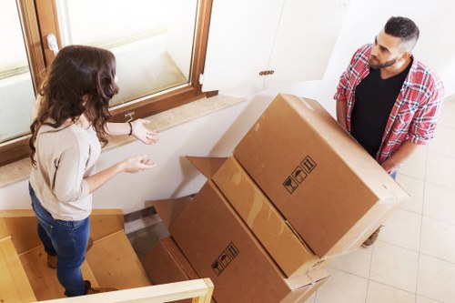 Packed office boxes and equipment ready for a commercial move in New Malden